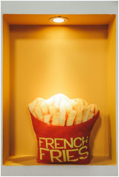 A vibrant French fries pillow under a spotlight in