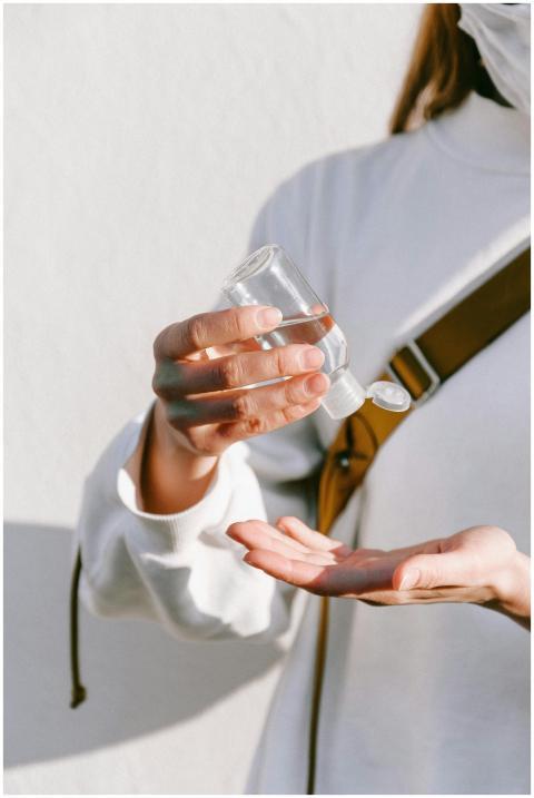 Close-up of a woman using hand sanitizer with a wh