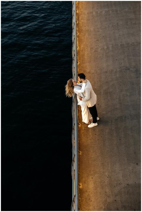 A couple embraces romantically on a sunset-lit sea