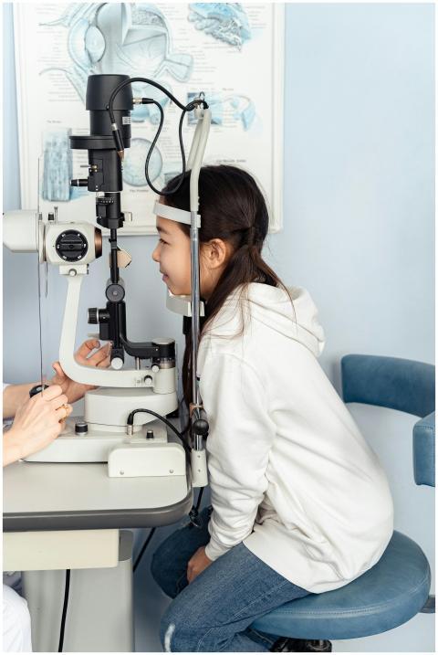 A young girl is undergoing an eye examination at a