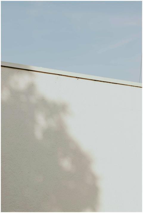 Shadow pattern on a white wall with a clear blue s