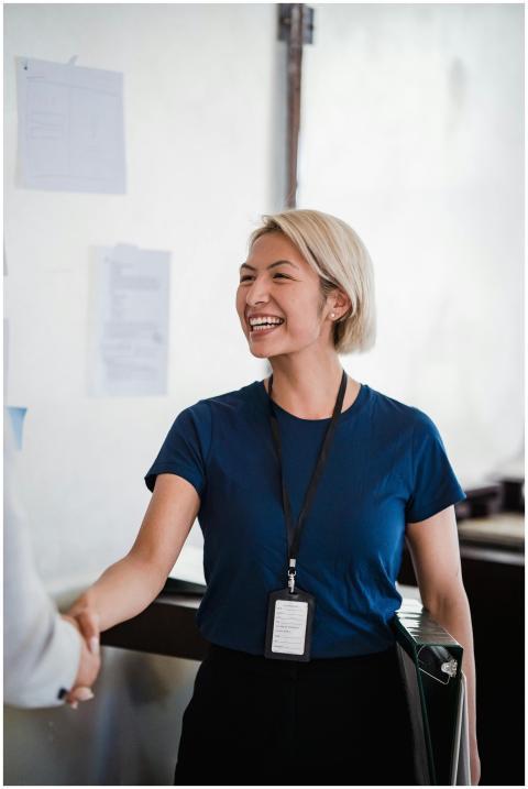 Friendly businesswoman in a blue shirt shaking han