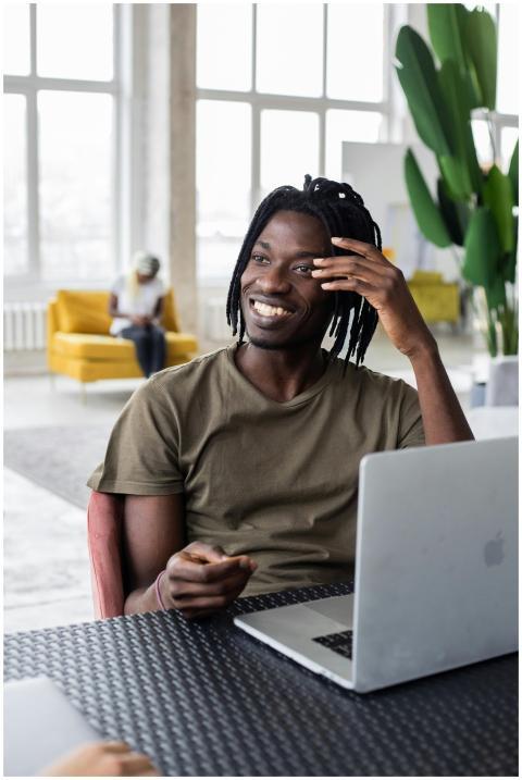 Cheerful young man using laptop in a contemporary