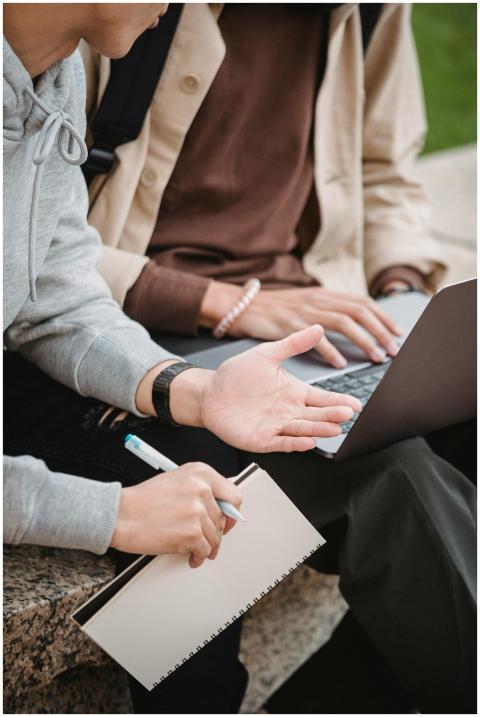 Two young adults collaborating with a laptop and n