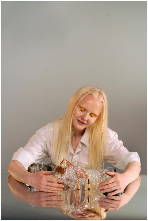 A woman with blonde hair in a studio interacts wit