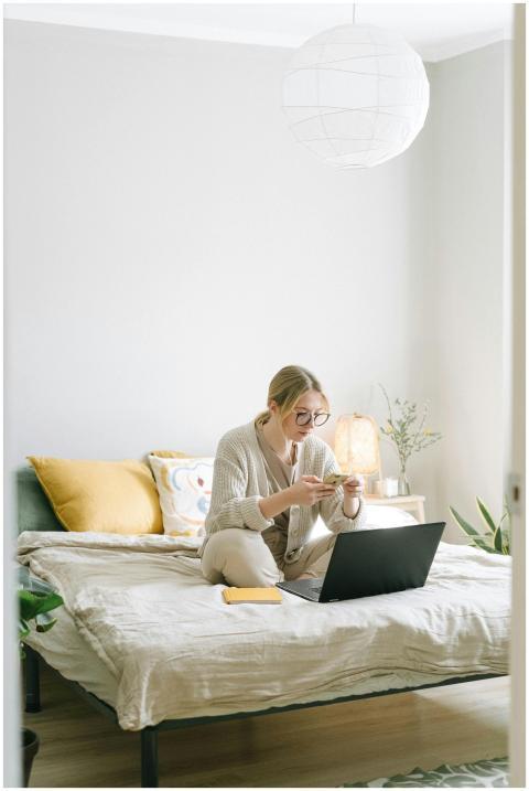 A focused woman works on her laptop while sitting