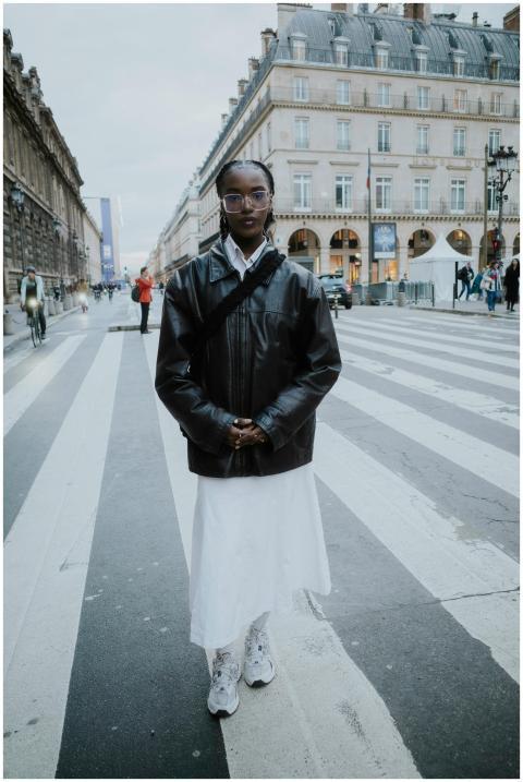 Stylish woman poses in a city crosswalk wearing a