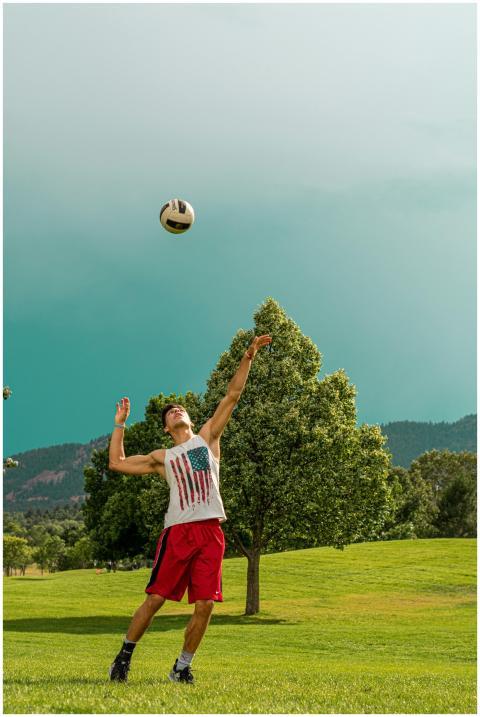 A young man jumps to hit a soccer ball in a sunny