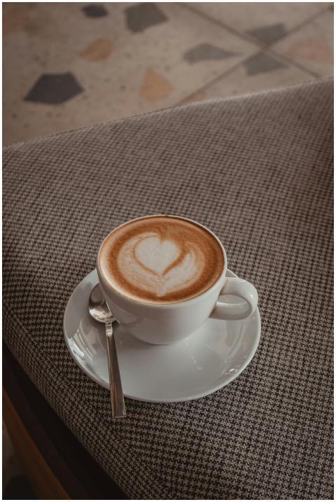 A cup of cappuccino with heart-shaped froth art on