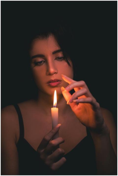 Moody portrait of a woman holding a candle, creati
