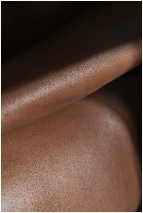 Artistic close-up of smooth brown skin texture hig