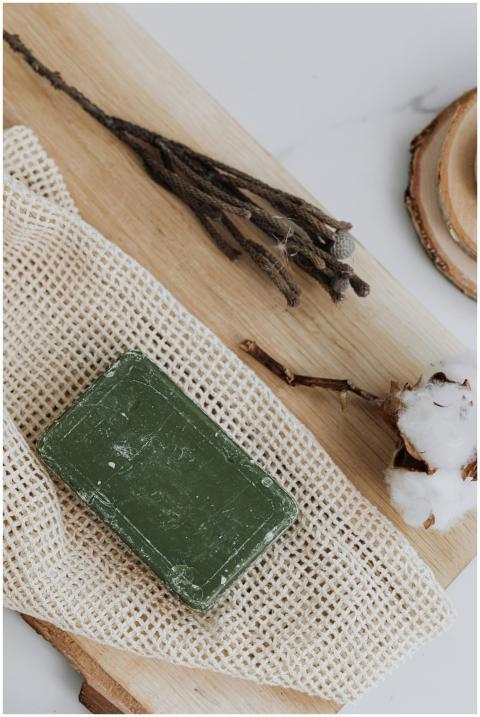 Organic green soap bar placed on a wooden board wi