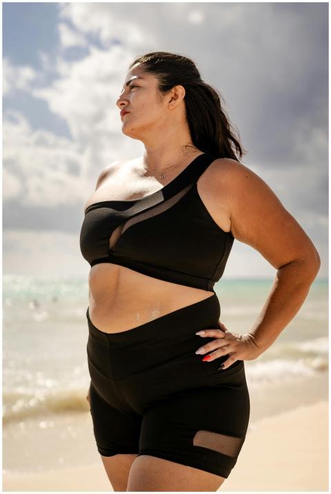 Confident woman in black swimwear standing on a su