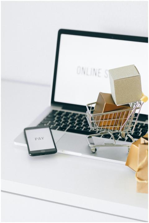 Mini shopping cart on laptop symbolizing online sh