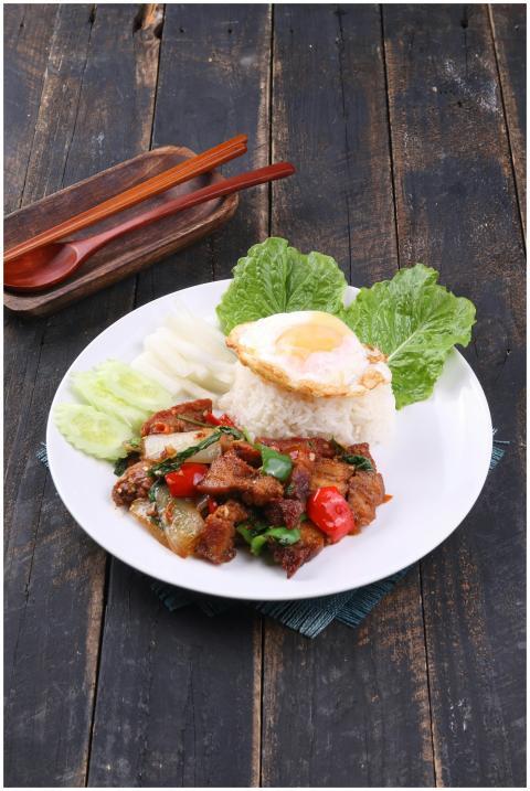 A vibrant Thai dish with basil beef, rice, egg, an