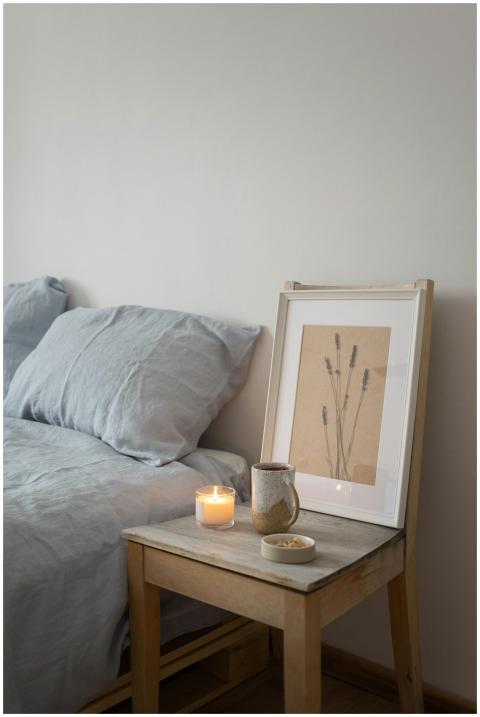 A serene bedroom featuring a wooden nightstand wit