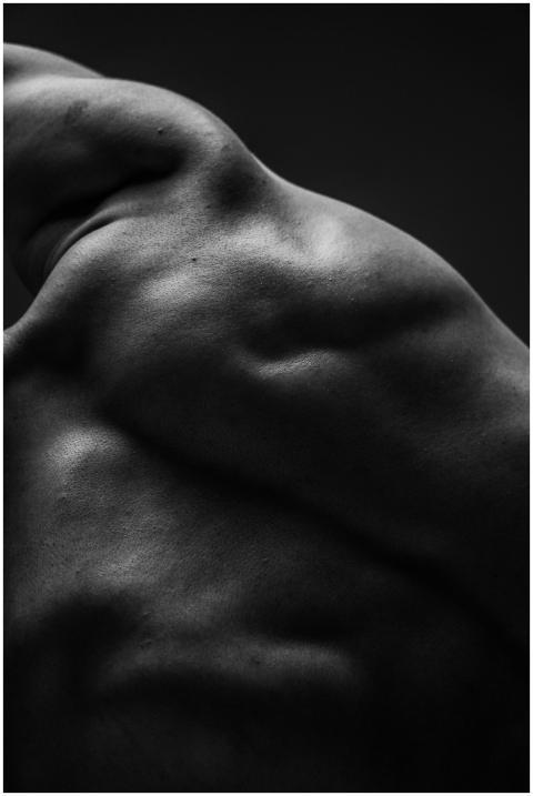 Dramatic black and white close-up of a muscular ma