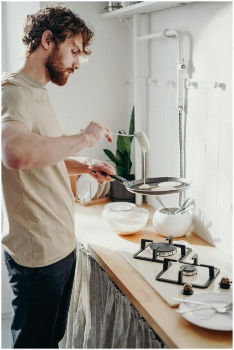 A man prepares delicious pancakes in a sunlit kitc