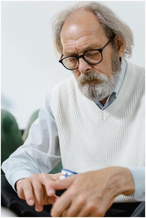 Elderly man using pulse oximeter to monitor blood