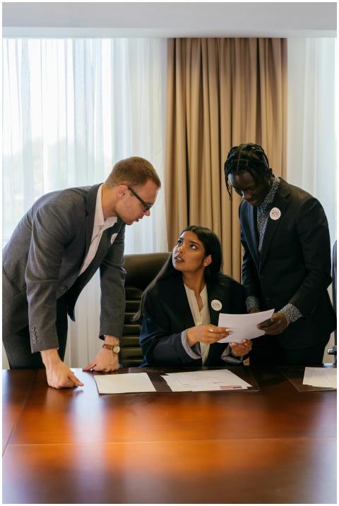 Three diverse professionals collaborate seriously