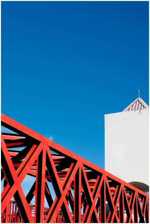 Striking red bridge structure against a clear blue