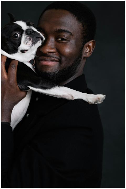 Portrait of a cheerful man holding a cute Boston T