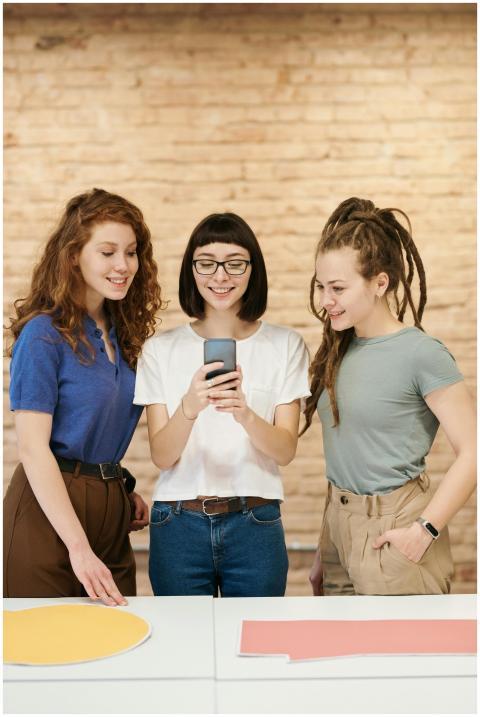 Three young women with stylish looks sharing a hap