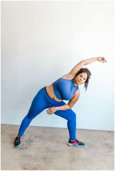 A confident plus size woman in blue activewear per