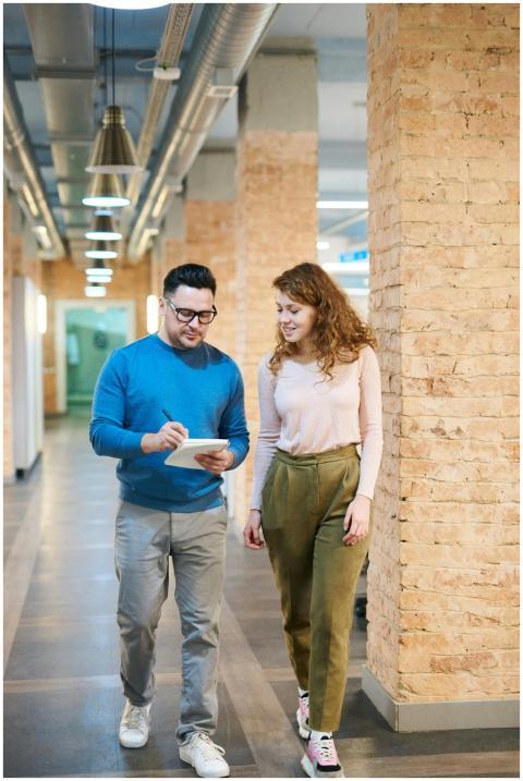 Two business colleagues walking in an office hallw