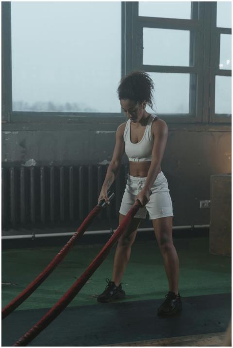 Focused woman using battle ropes for an intense wo