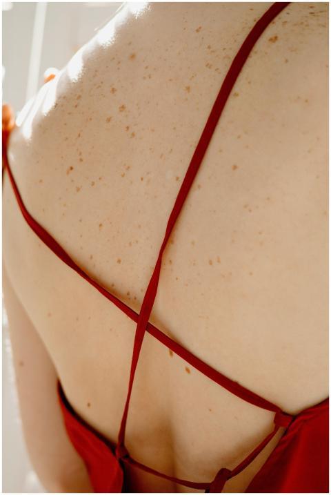 A close-up of a person's freckled back in a strapp