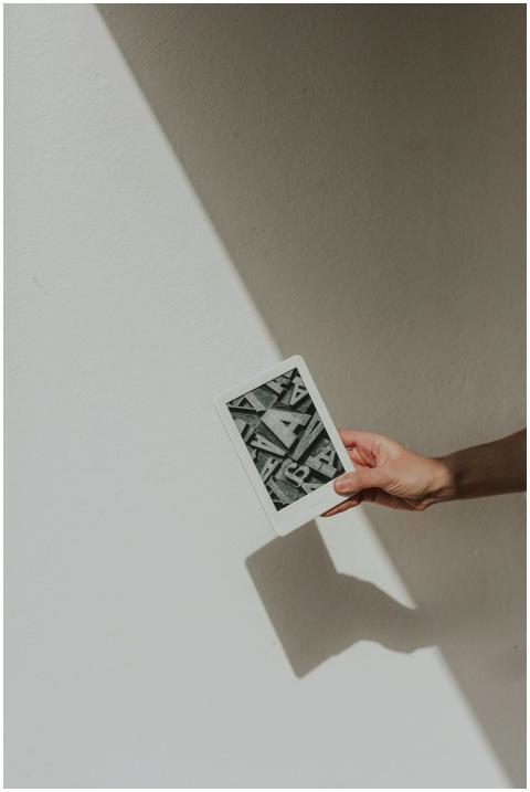 A minimalist photo featuring a hand holding a tabl