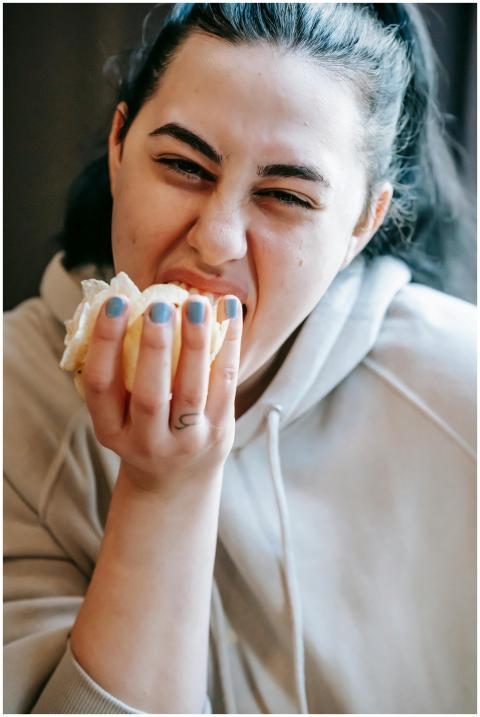 Close-up of a young woman biting into a tasty sand