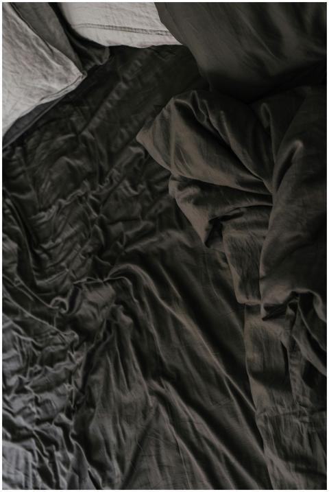 High-angle view of creased dark linen bedding crea