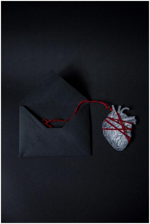 Conceptual black envelope and heart with red strin