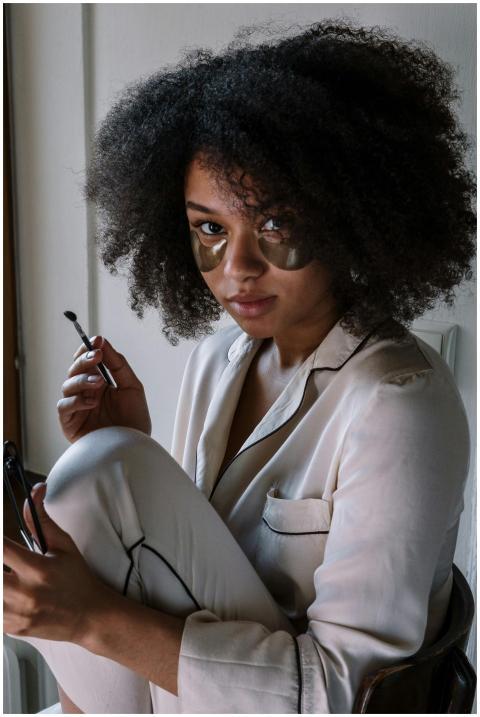 Beautiful woman in pajamas applying skincare routi