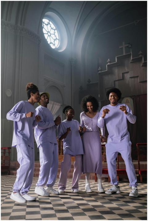 A diverse group of adults singing and dancing joyf