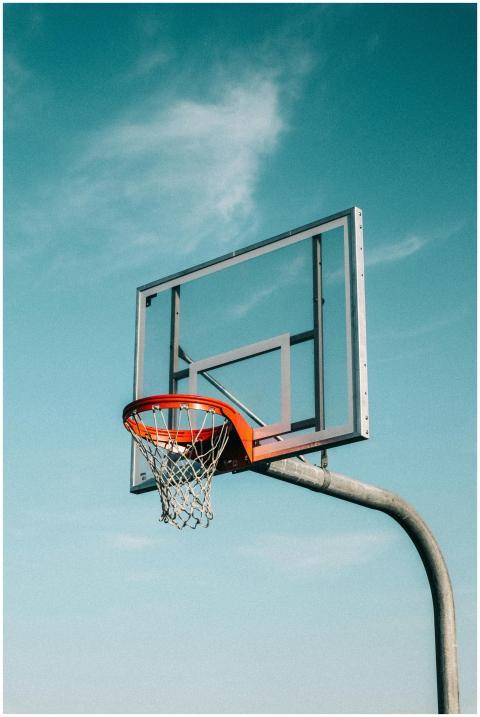 A basketball hoop outdoors against a clear blue sk