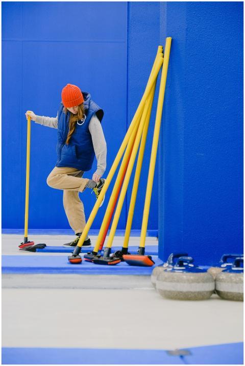 A woman in sportswear gets ready for curling indoo