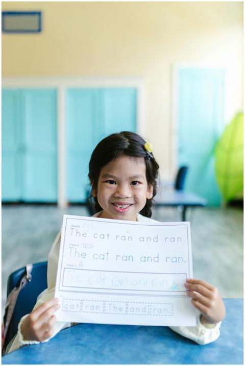 A young girl smiles while showing her finished han