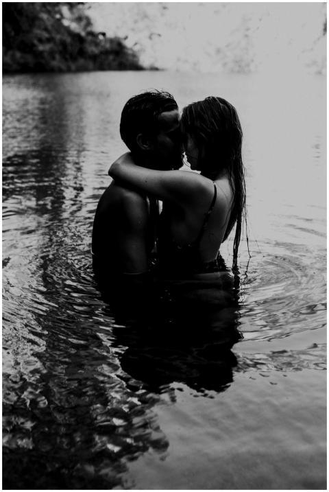 A couple tenderly hugging in a serene lagoon durin