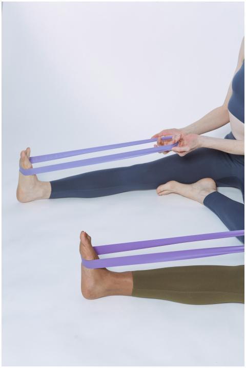 Two women using purple resistance bands for a fitn