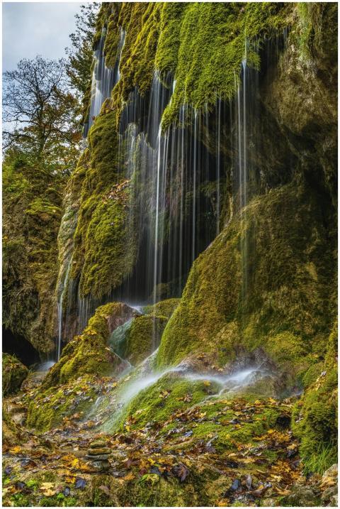 Tranquil waterfall cascading over mossy rocks in a