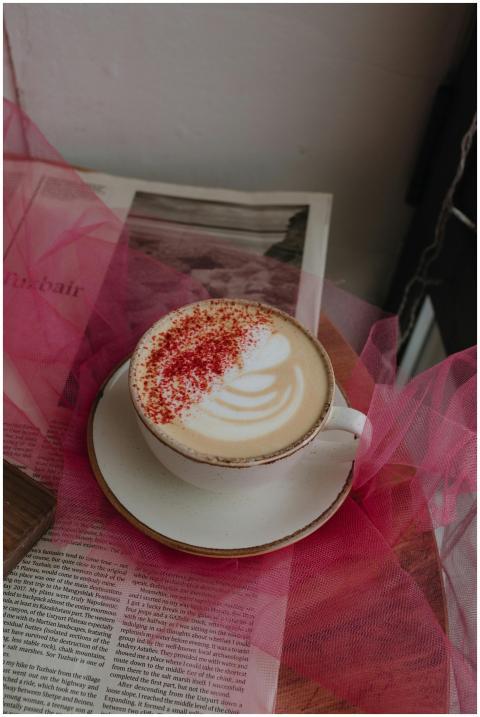 A cappuccino with froth art and red sprinkles on a