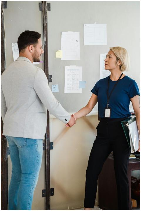 Two professionals shaking hands in an office setti