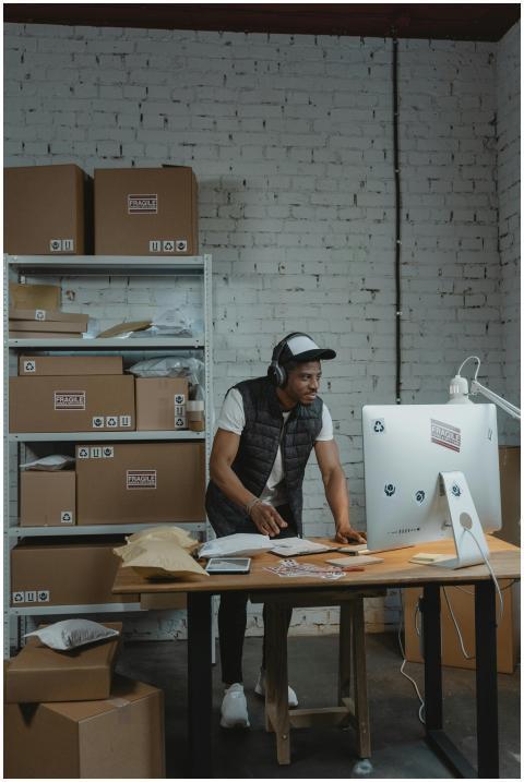 A man in a warehouse packaging orders for shipping