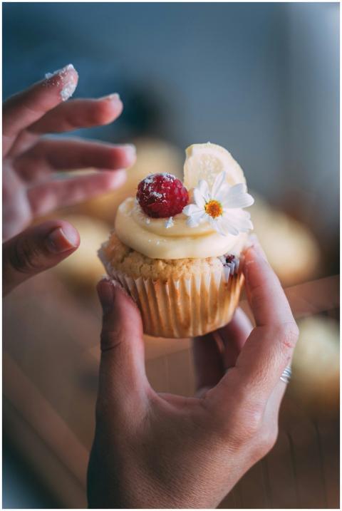 Close-up of a cupcake topped with raspberry, cream