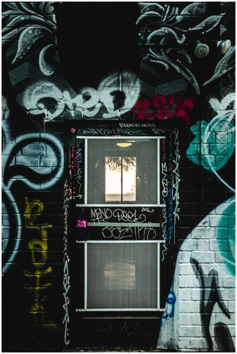 Vibrant graffiti covers a brick wall with a window