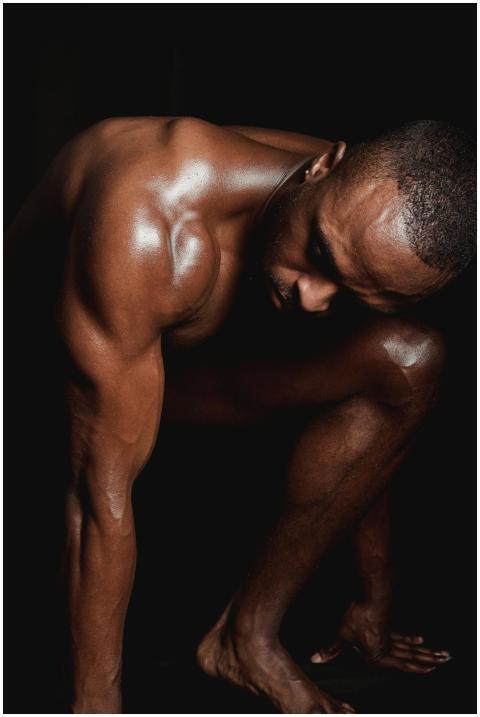 Artistic shot of a shirtless muscular man bending