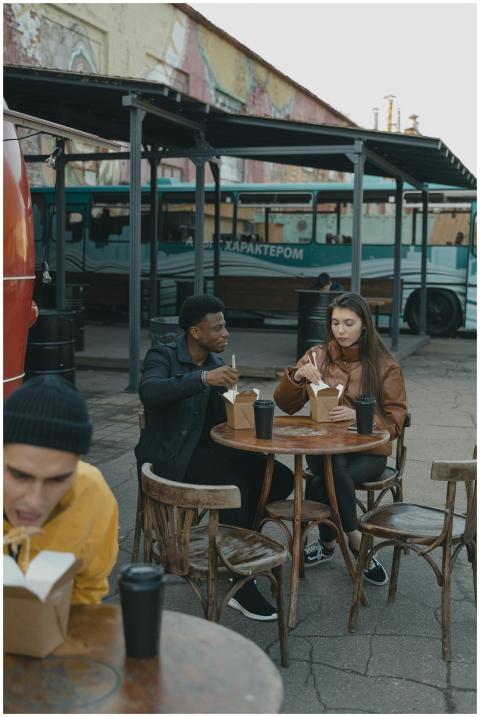 Young adults enjoying takeaway food at an outdoor